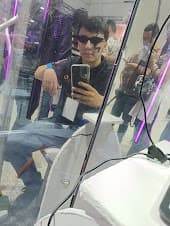 Yo reflejado en el espejo de una de las instalaciones interactivas con IA que armamos para el evento, bajo luces moradas.
